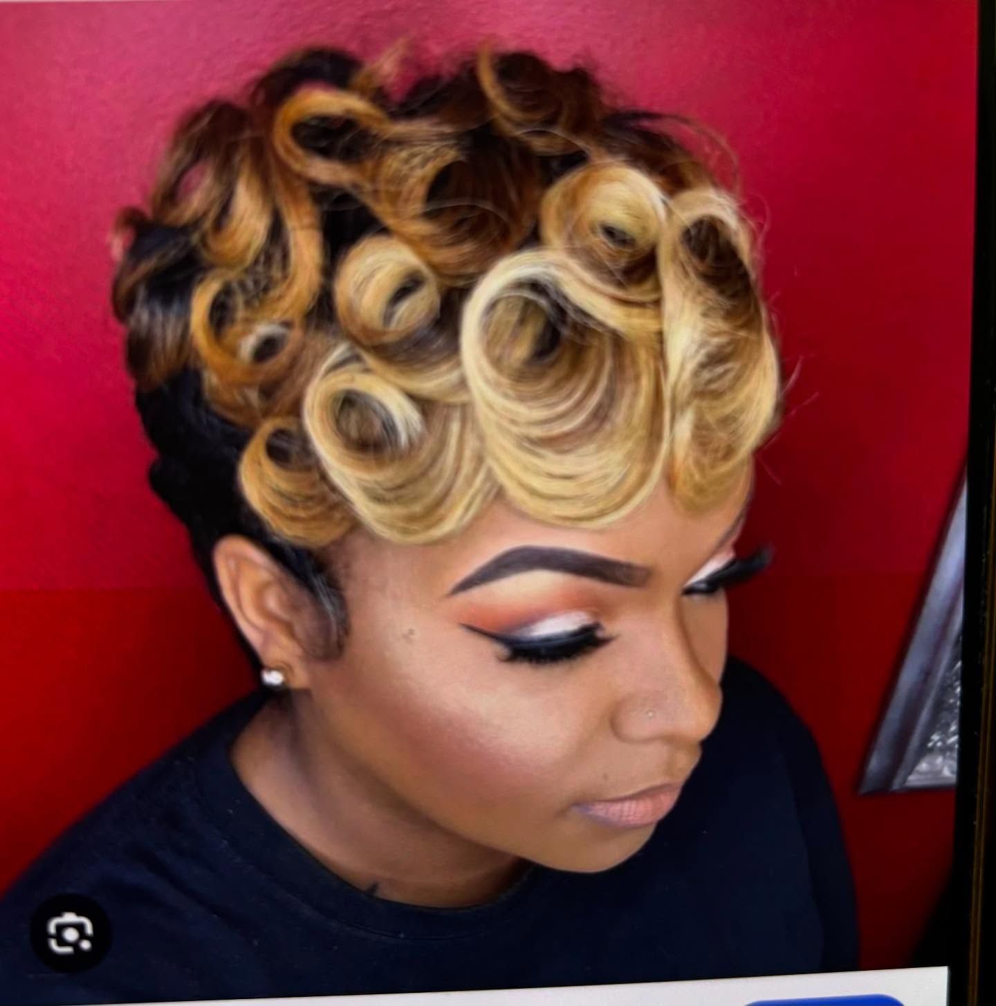 Woman with short, auburn hair in a hair salon; a person with a grimace in the foreground.