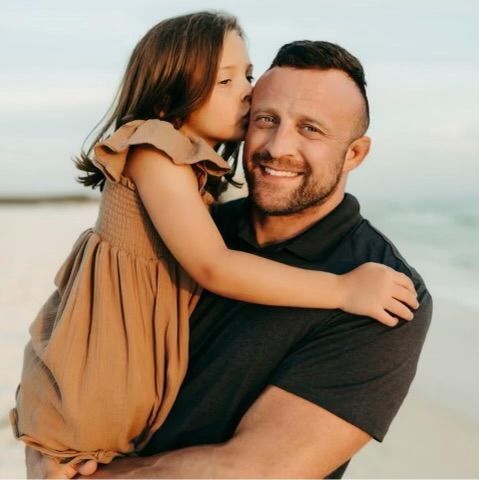 A little girl kisses his father on the cheek