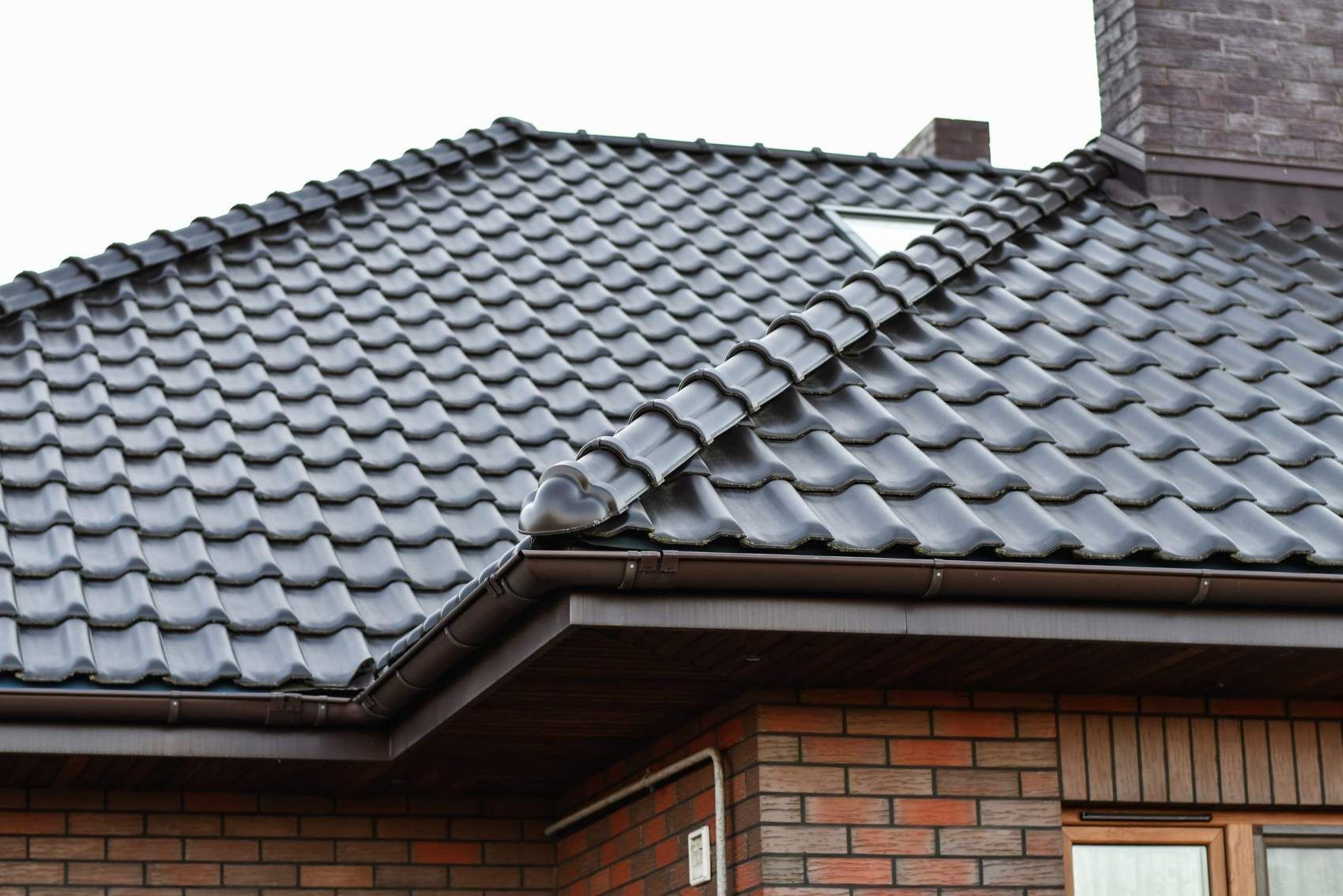 A brick house with a tiled roof and a skylight