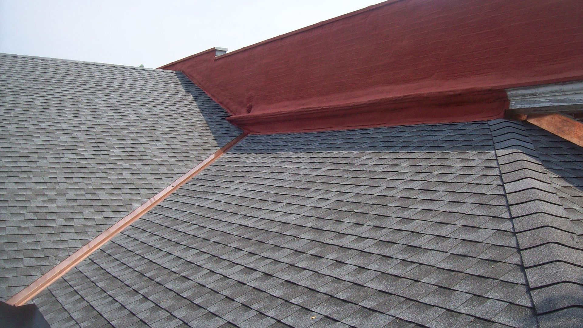 A close up of a roof with a copper gutter