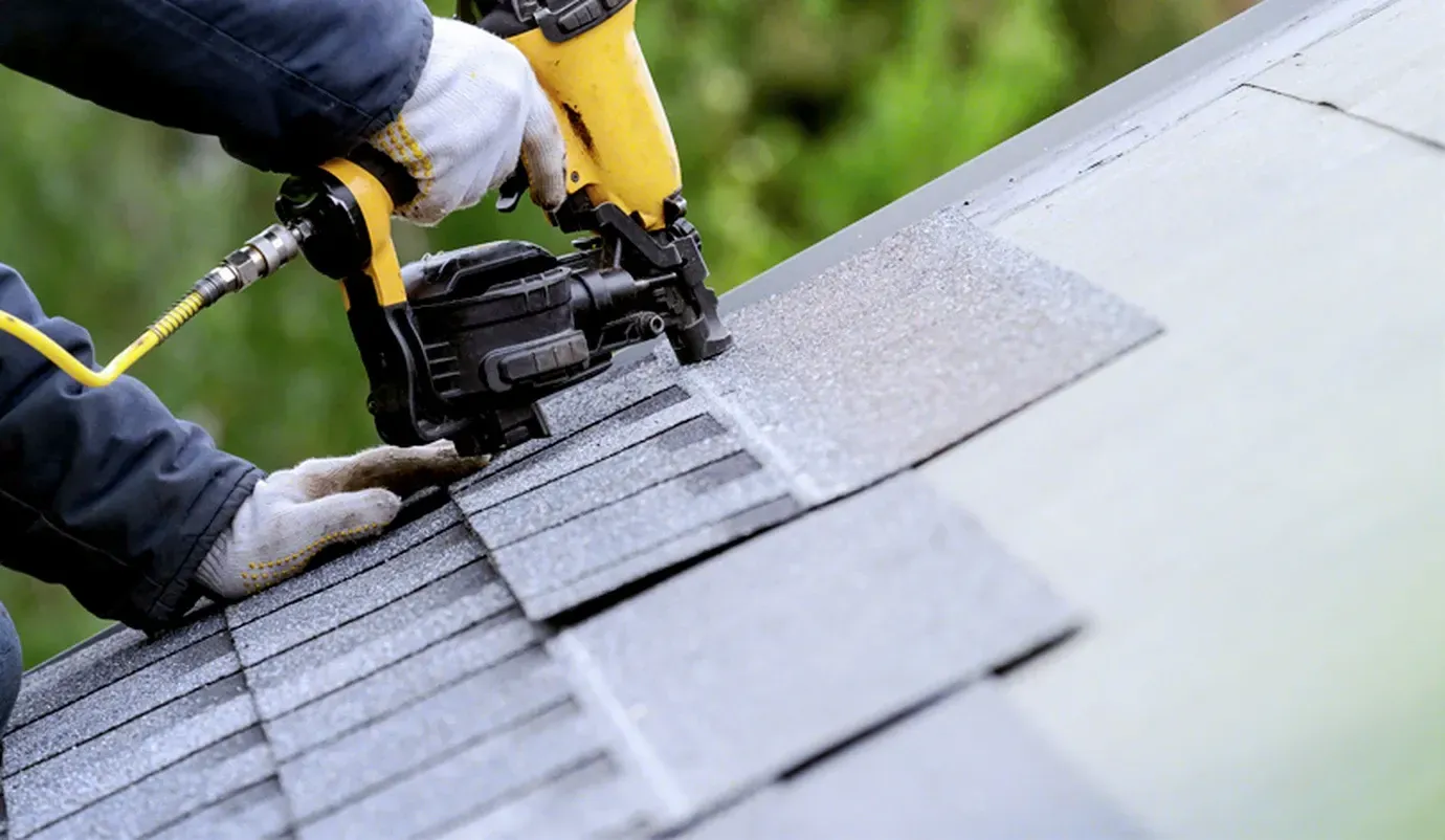A man is installing a slate roof on a house.
