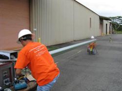 A professional working on a rain gutter installation in Waipahu, HI
