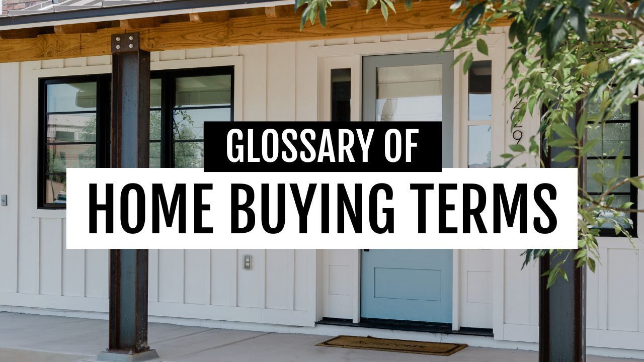 A white house with a blue door and a sign that says glossary of home buying terms.