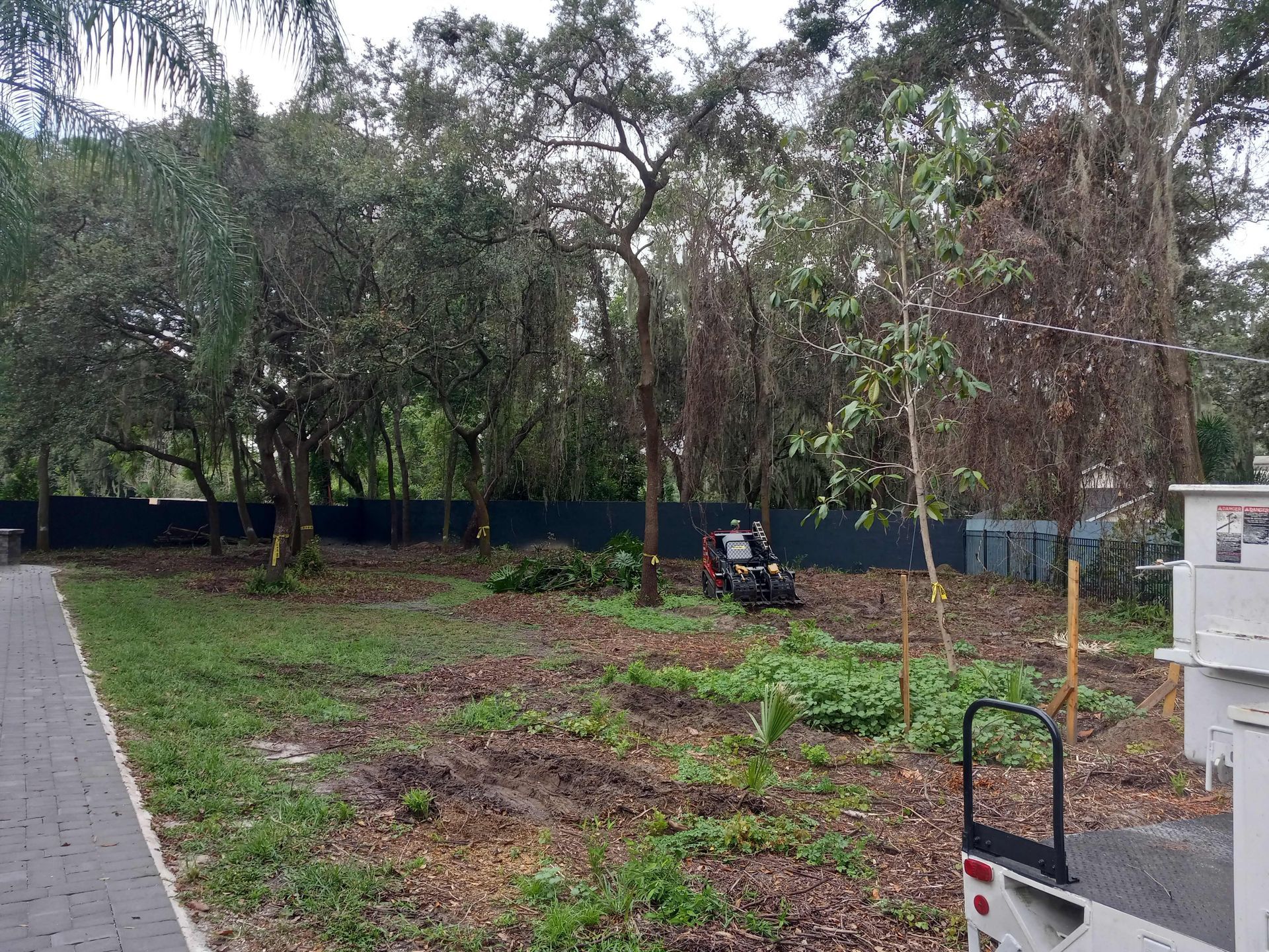 A truck is parked in the middle of a field with trees in the background.