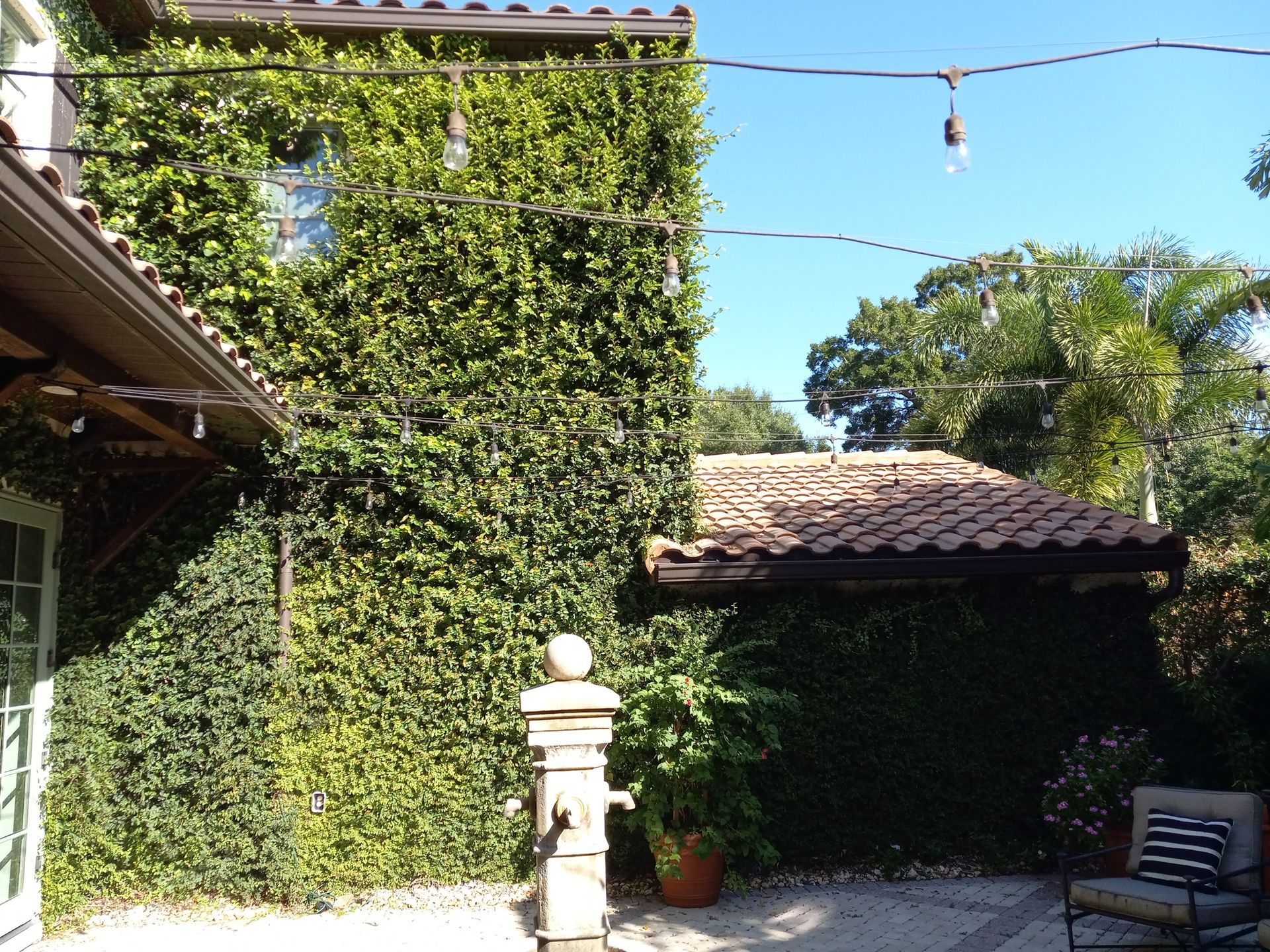 The backyard of a house with a water fountain and chairs