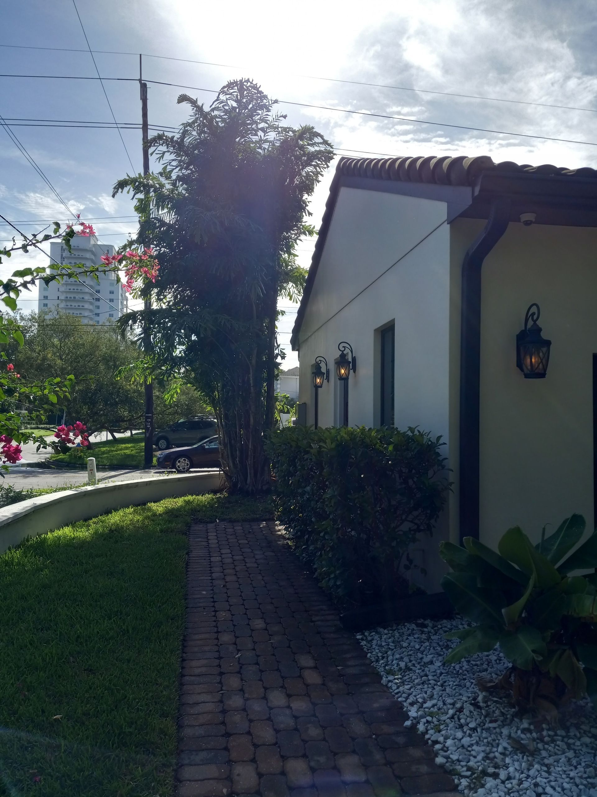 A white house with a brick walkway leading to it