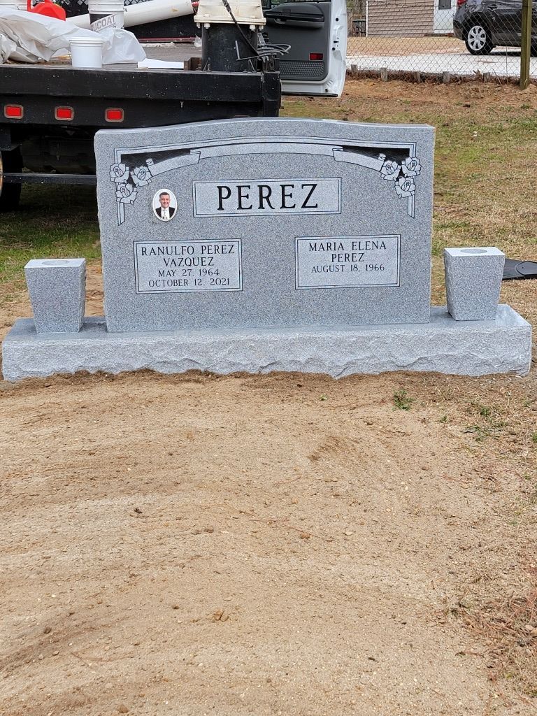 a gravestone for perez is sitting in the dirt in front of a truck .