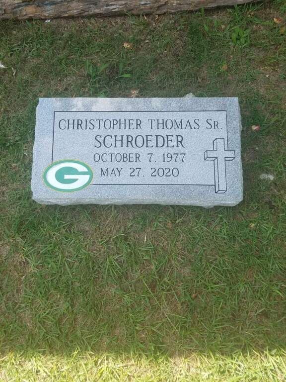 a gravestone with a green bay packers logo on it