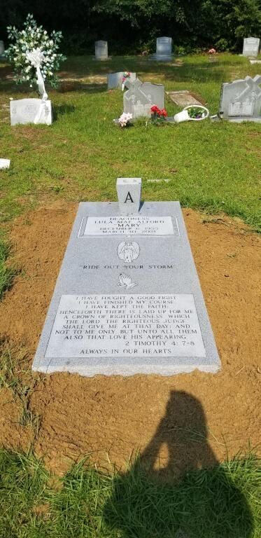 a grave in a cemetery with a cross on it .