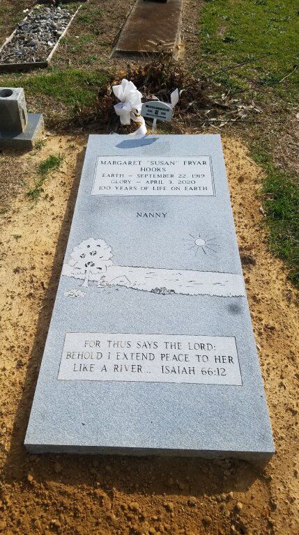 a gravestone in a cemetery with flowers on it .