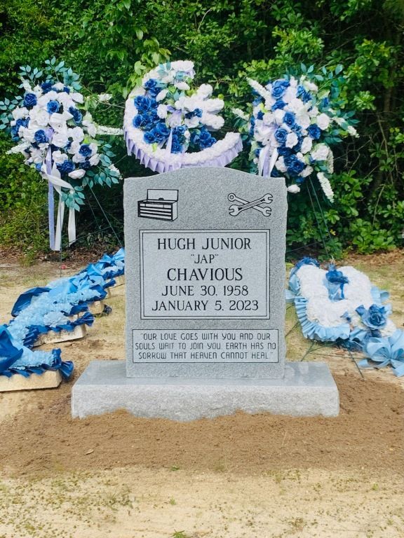 a gravestone for hugh junior is decorated with blue and white flowers .