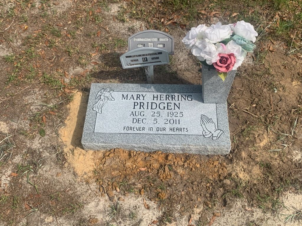 a gravestone with flowers on it in a cemetery .