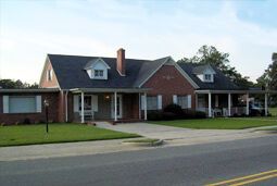 a large brick house with a blue roof and a porch .