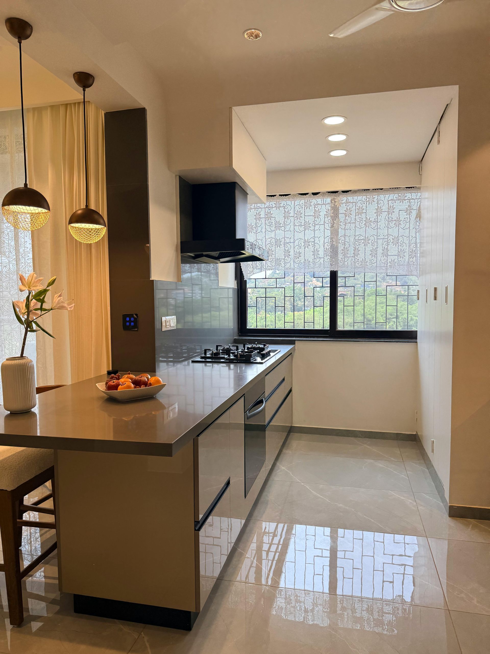 Le porte con persiane nere si aprono rivelando un soggiorno e un patio esterno.