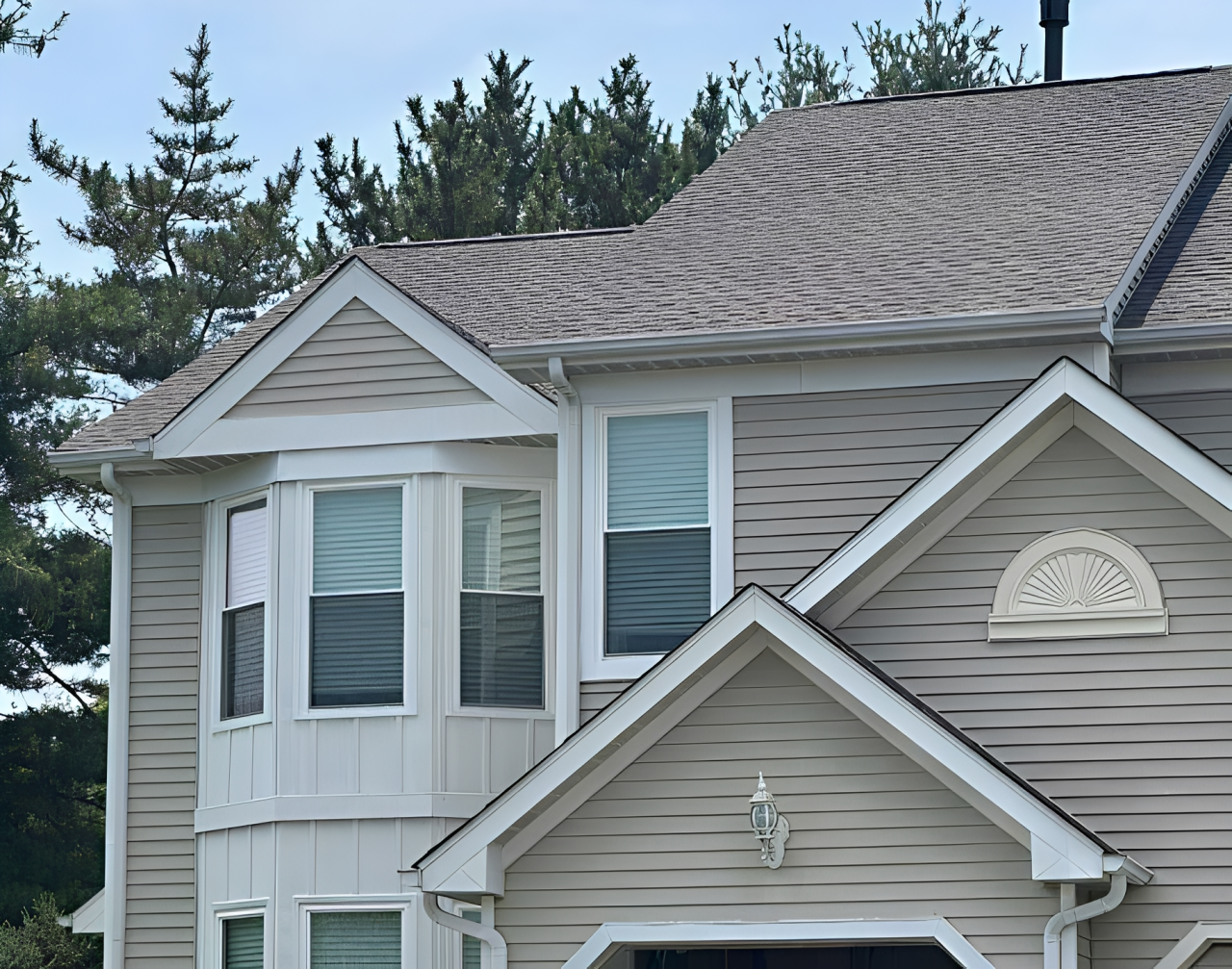 Two-story house with light siding and dark roof streaks; white trim.