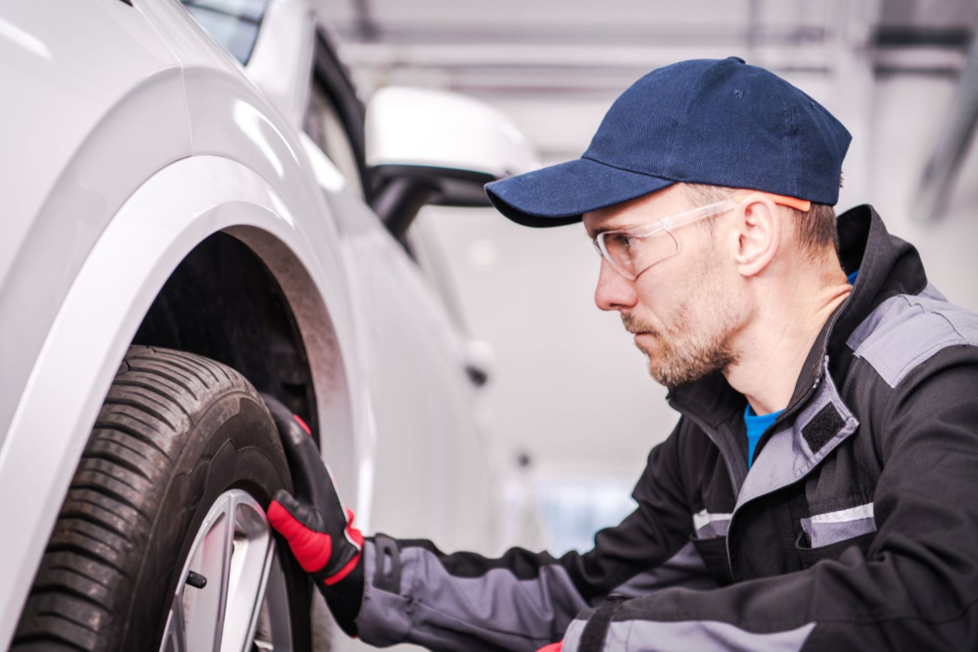 A Man is Working on a Car Wheel in a Garage — Alstonville Rego & Mechanical in Alstonville, NSW