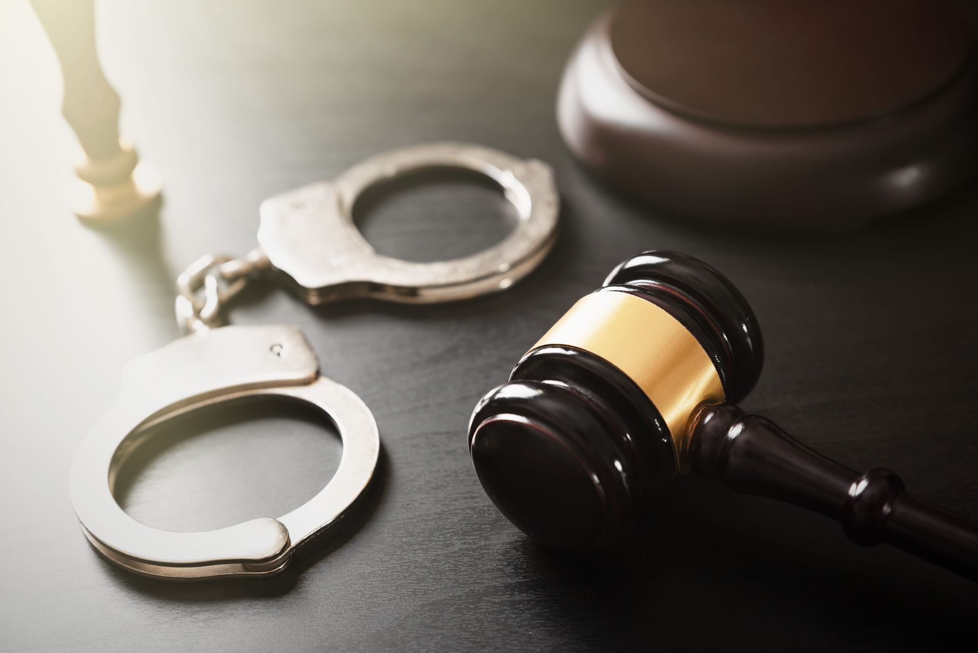 A pair of handcuffs and a judge's gavel on a table.