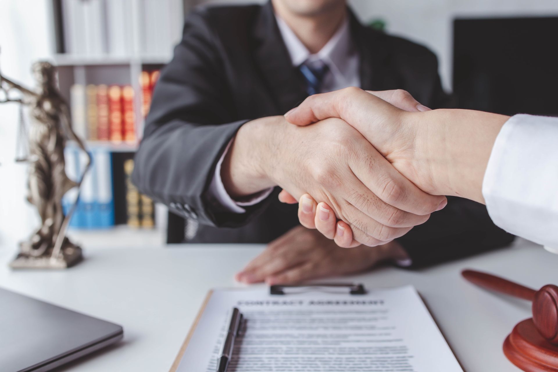 A man in a suit and tie is shaking hands with another man.