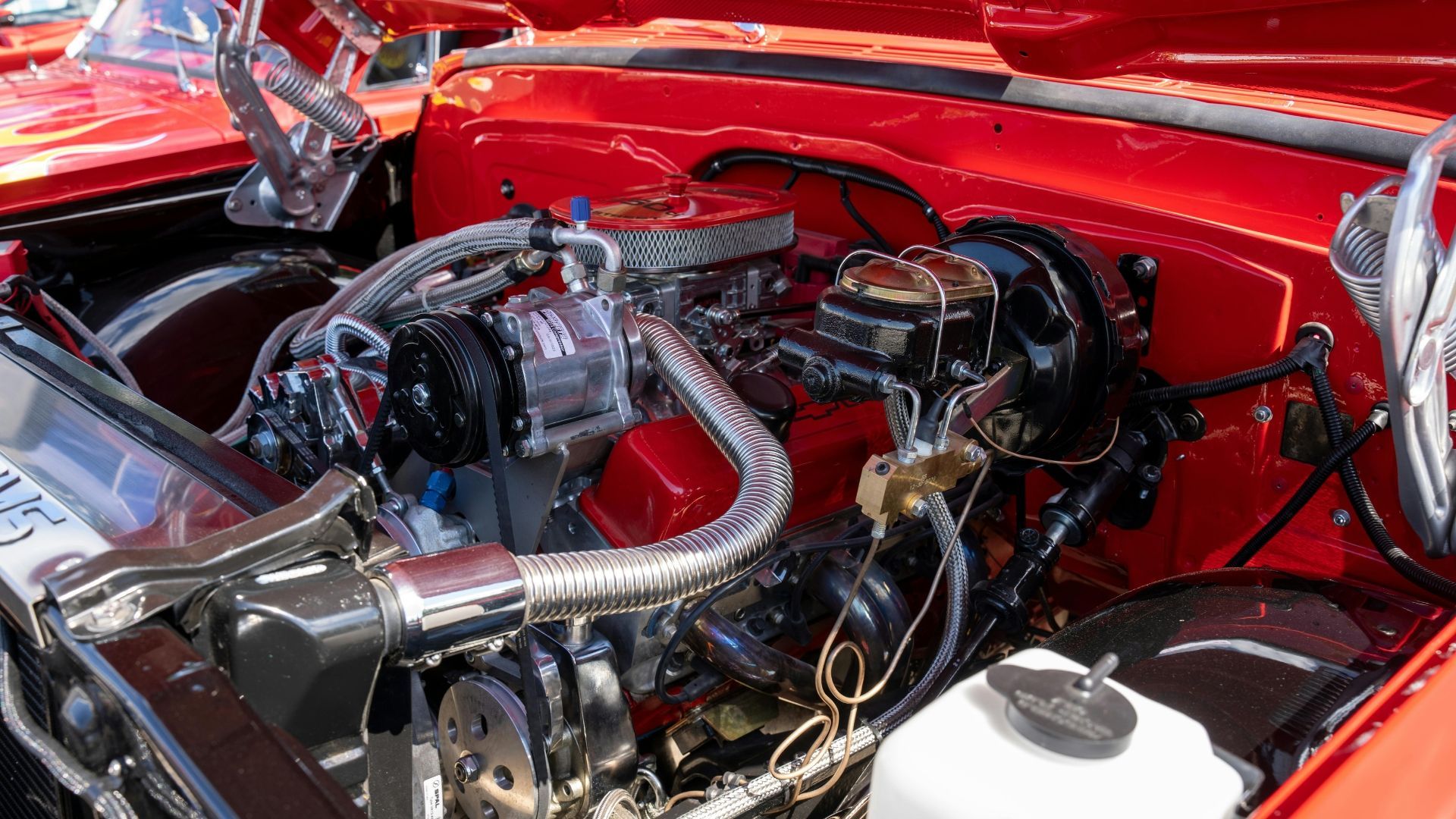 Red classic car engine with chrome details.