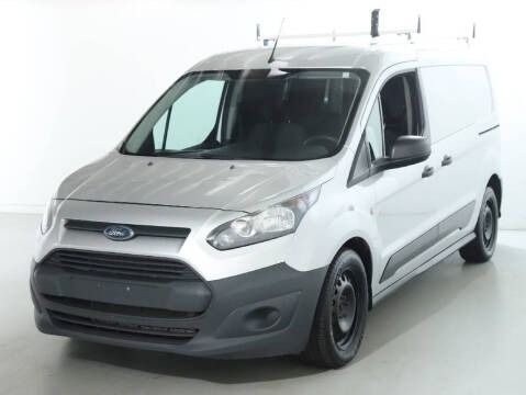 Silver Ford Transit Connect cargo van with roof rack, parked in a studio.