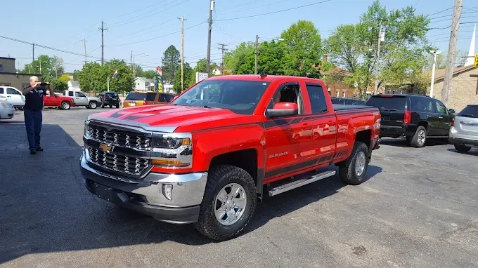 White GMC Sierra truck parked in a parking lot on a sunny day.