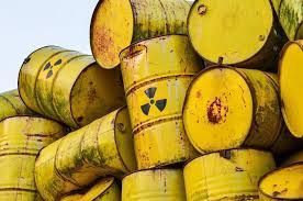 Yellow barrels with radioactive symbols stacked, likely containing nuclear waste.