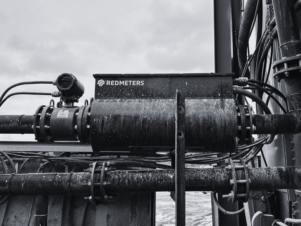 Black and white photo of industrial pipes with a box labeled