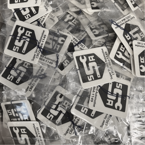 Pile of small black-and-white packaged cards or labels scattered together.