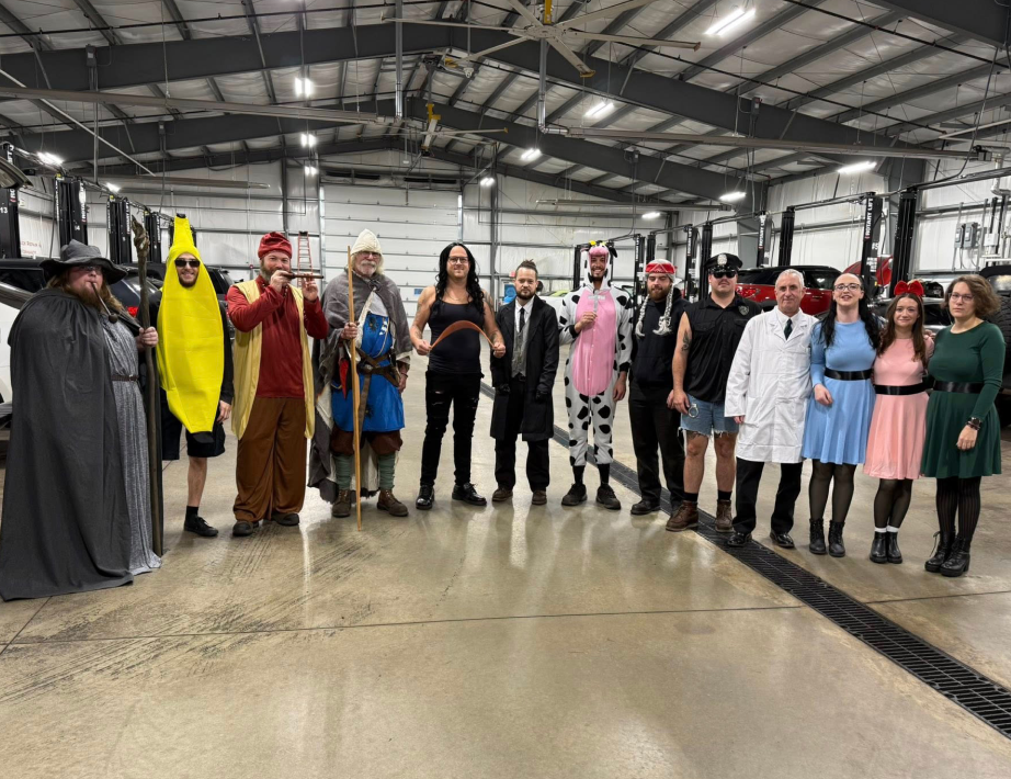 Costumed group posing in a warehouse, including a banana, wizard, and lab coat characters.