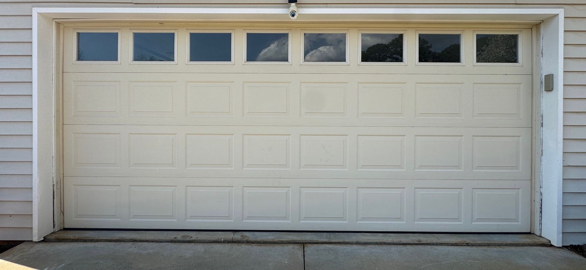White garage door with windows in a house facade.