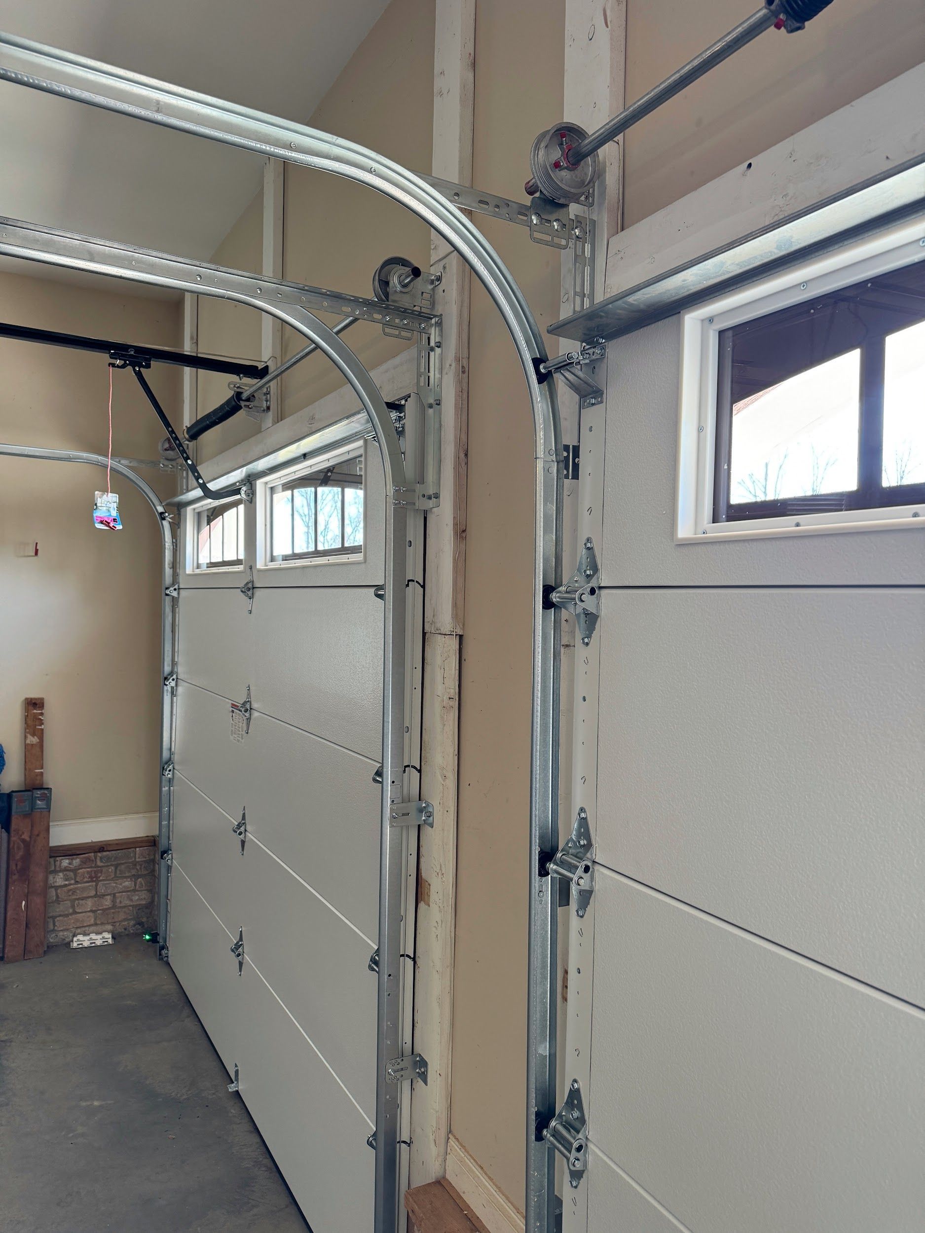 Garage door, white panels, curved track, installed. Interior shot.