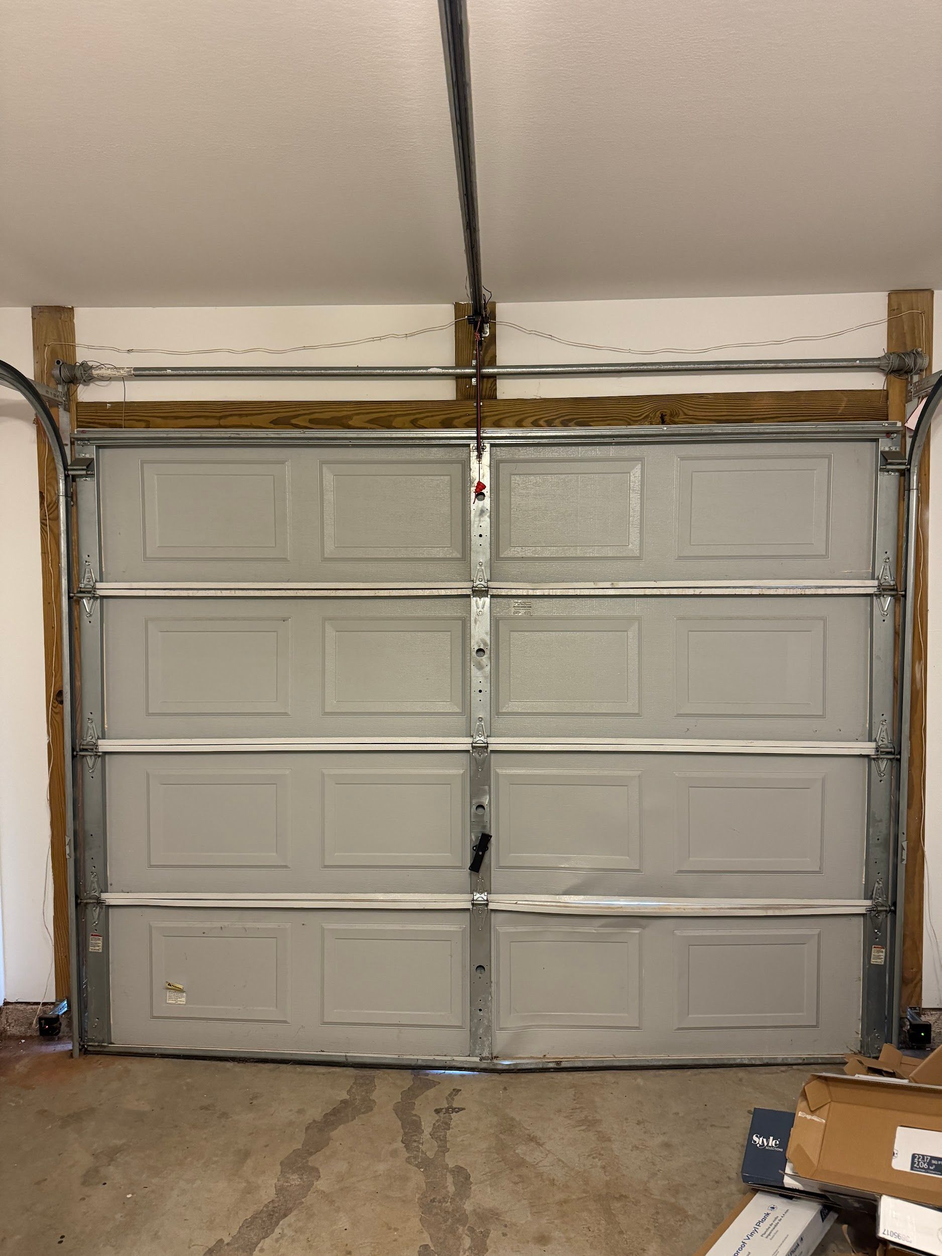 Closed gray garage door with wooden frame in a garage.