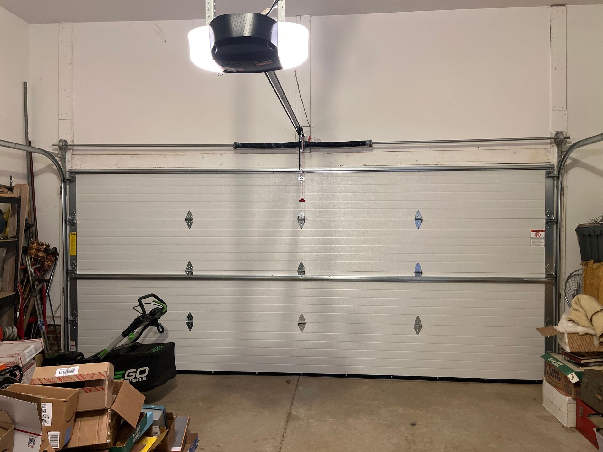 Garage interior with a closed white garage door and an overhead opener.