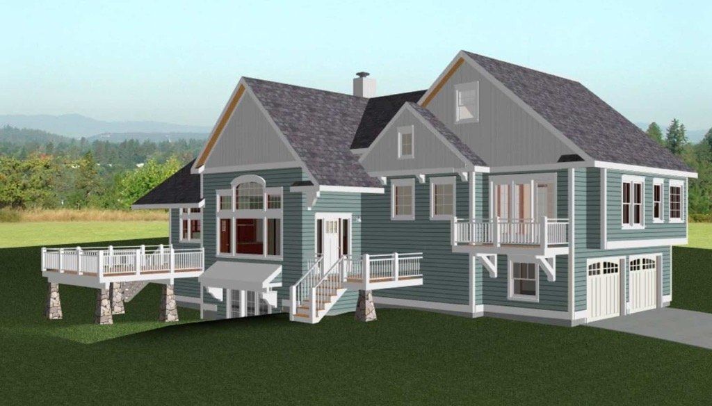 Modern gray two-story house with a porch, deck, and garage in a green rural setting