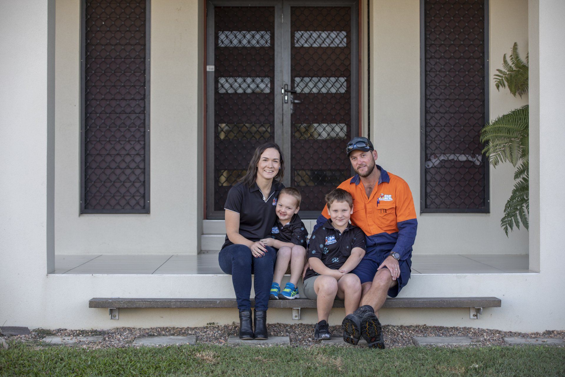 A Family is Sitting on the porch of their house - SIC Airconditioning & Refrigeration in Townsville