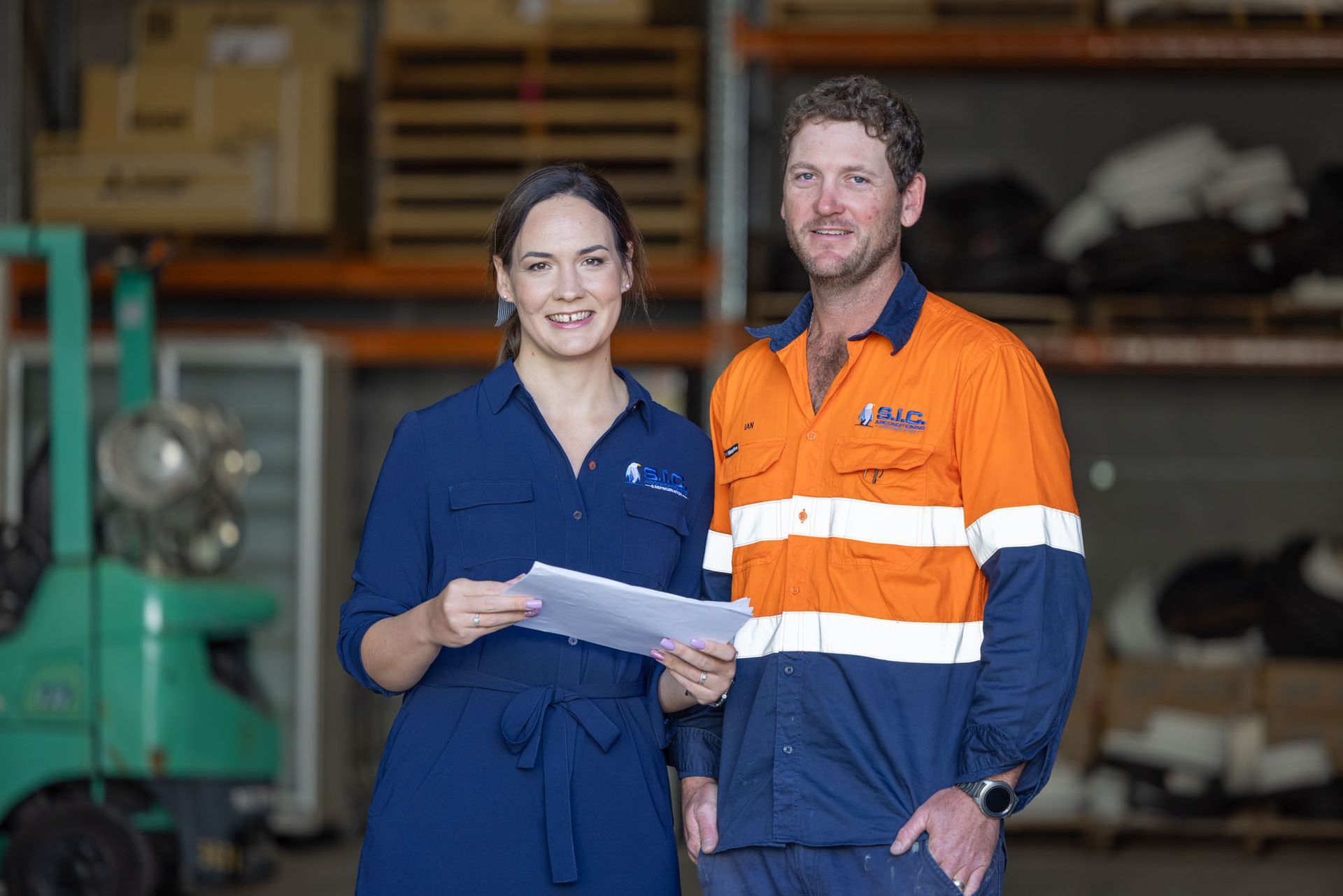 A man and a Woman are Standing next to each other in a Warehouse. - SIC Airconditioning & Refrigeration in Townsville