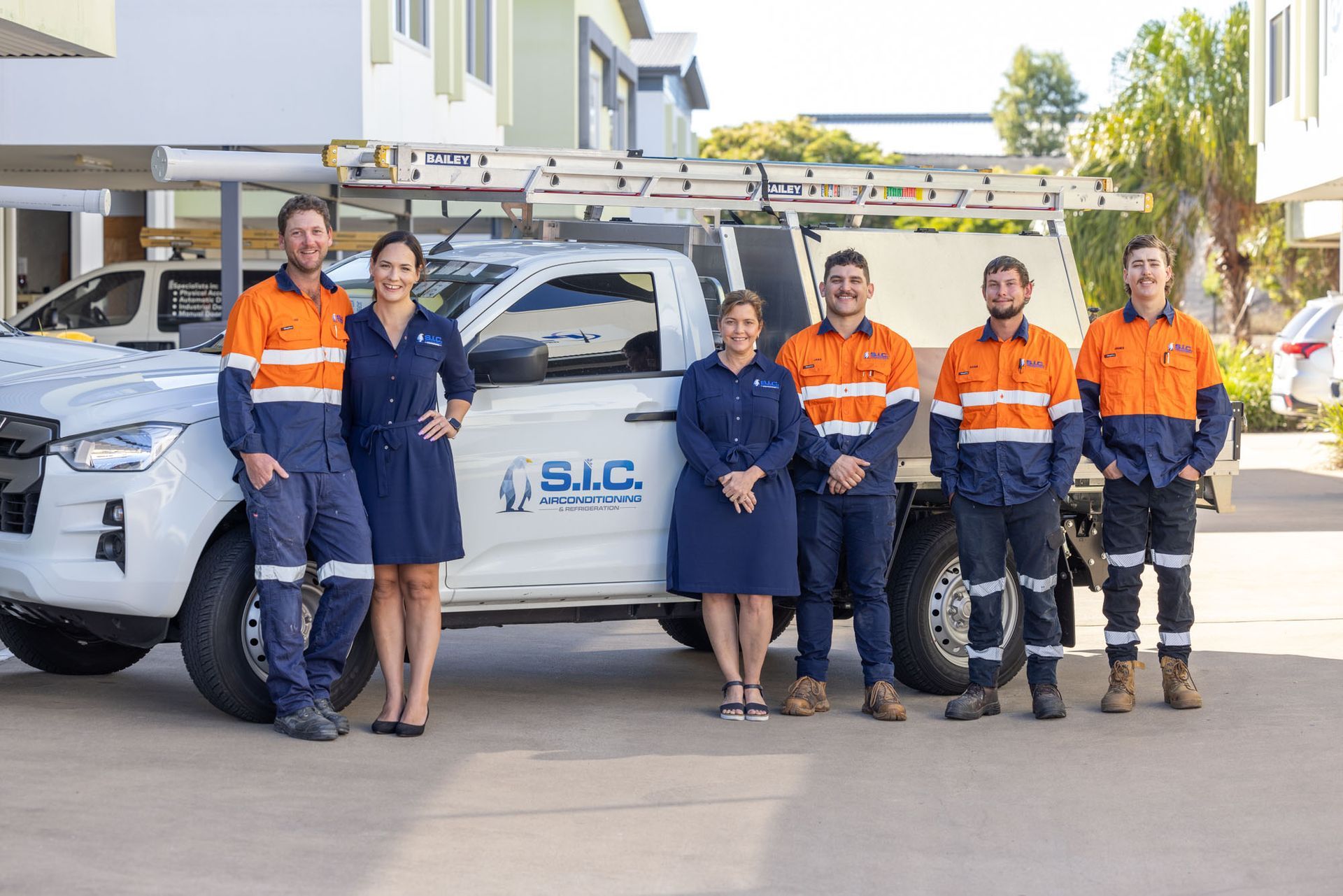 Two man at Orange Shirt Standing beside of Truck Services, SIC Airconditioning & Refrigeration in Townsville