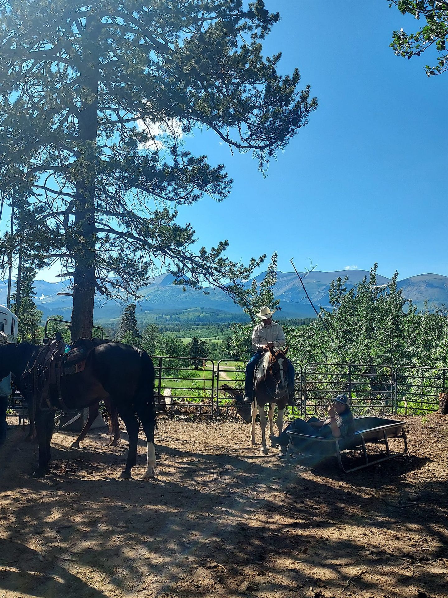 A Man is Riding a Horse in a Dirt Field With Mountains in the Background