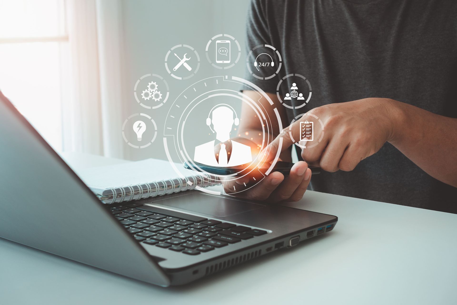 Person using a laptop and phone with a customer service icon overlaid.