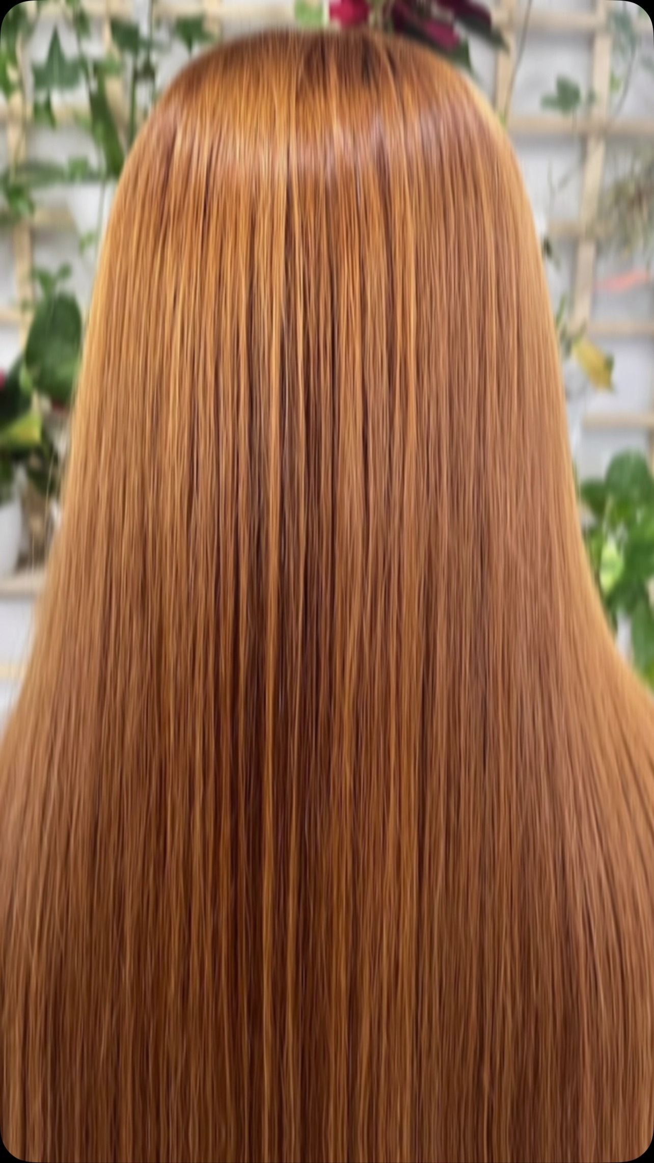 Vista posteriore di lunghi capelli lisci color rame in un ambiente interno ben illuminato.