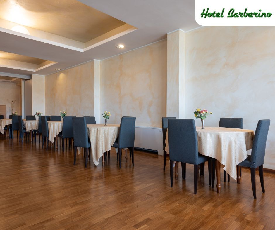 Ci sono molti tavoli e sedie nella stanza.