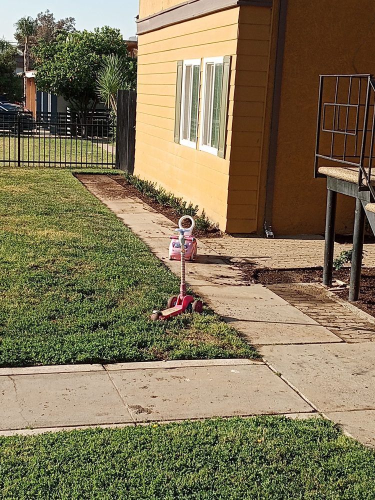 A scooter is parked on the sidewalk in front of a house.