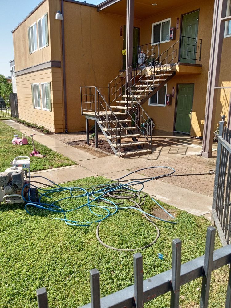 A building with stairs and a hose in front of it.