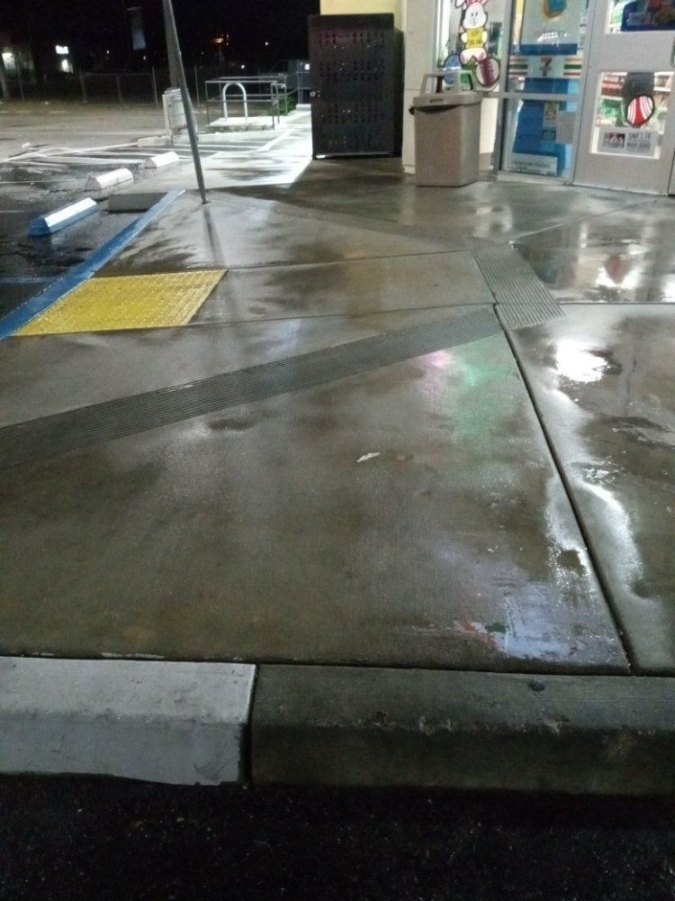 A dirty concrete floor at a gas station at night.