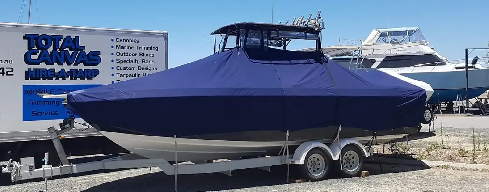 Custom-fit navy blue boat cover protecting a boat