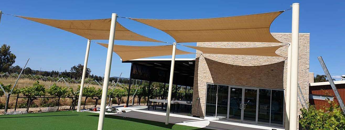 Custom-designed and installed canopies create a shaded outdoor dining area.