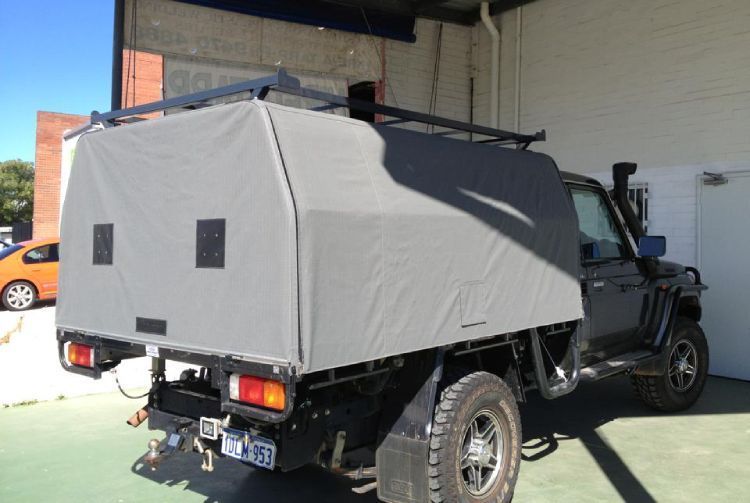 Gray UTE canopy cover on a vehicle parked outdoors, showcasing the custom fit and durable fabric.