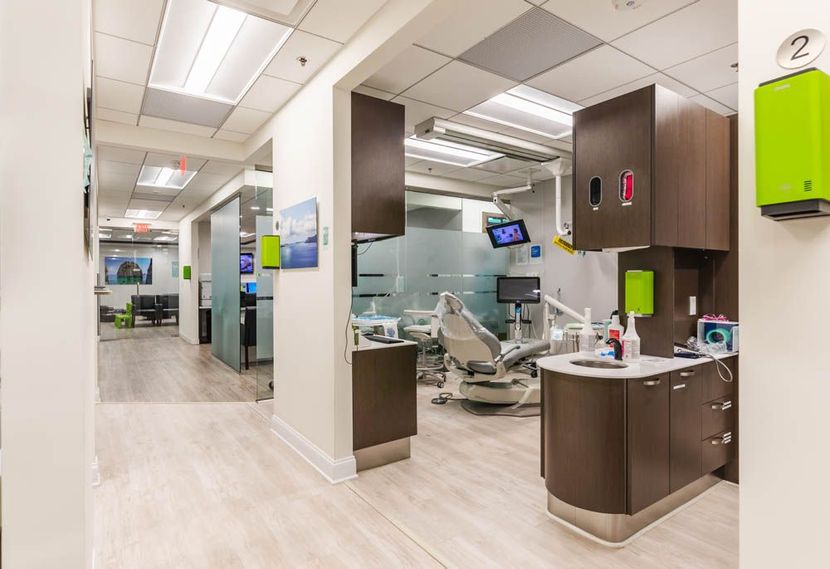 Dental office interior with patient chairs, cabinets, and a hallway.