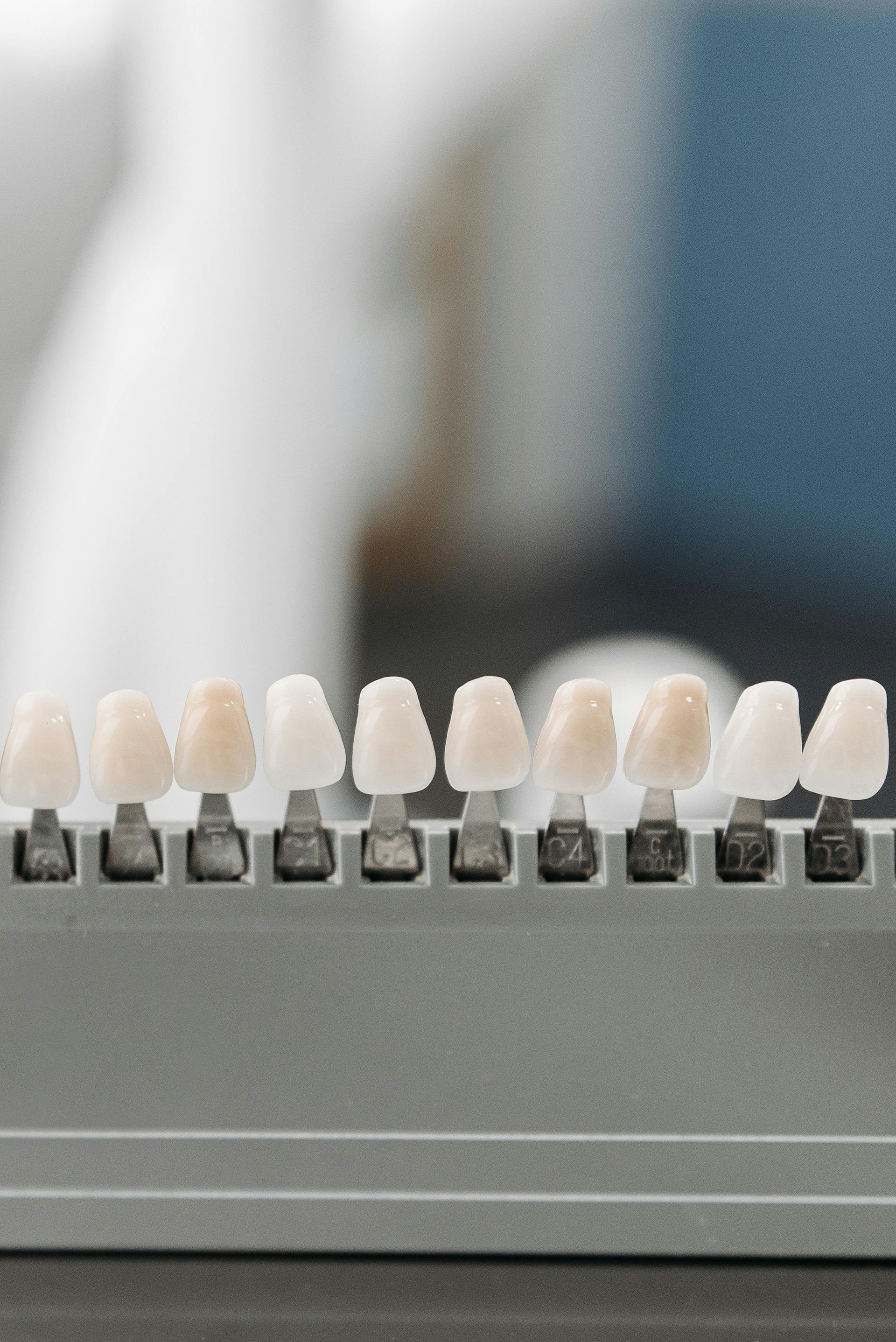 Teeth shades arranged in a dental shade guide for comparison, showing varying levels of whiteness.