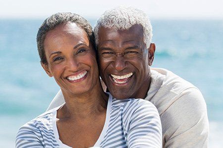Smiling African-American couple |  full mouth rehabilitation services | Dentures Wellington